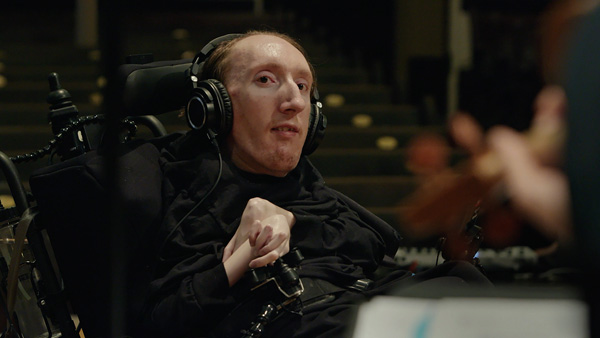Composer Ari Kinarthy with headphones on at his digital audio workstation.