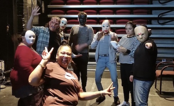 Gaitrie Persaud-Killings and a group of actors in Commedia dell'arte masks pose for a spontaneous picture.