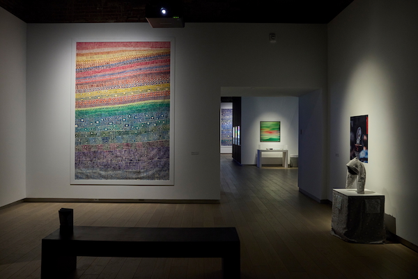 Installation view of the Bucko Art Machine survey exhibition at SAW gallery. In the foreground is a large colourful abstract painting.