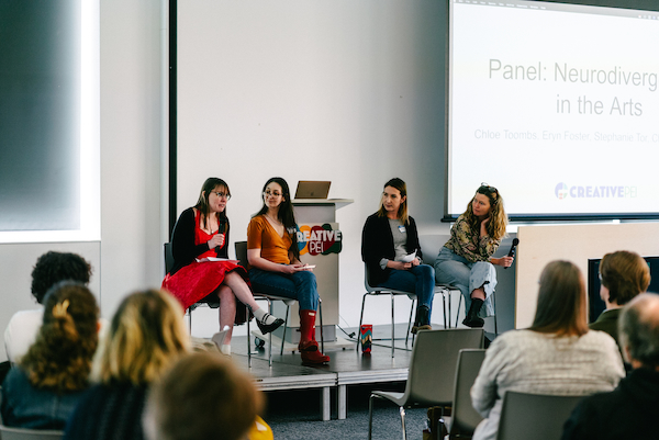 Four artists on stage at Creative PEI's Arts, Access, & Wellbeing Conference for a panel discussion titled Neurodivergence in the Arts